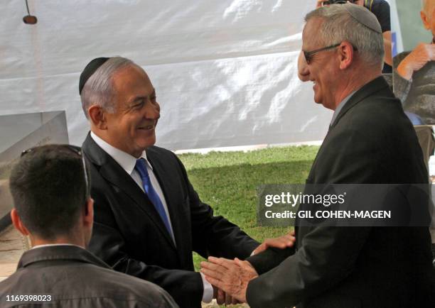 Israeli Prime Minister Benjamin Netanyahu greets Benny Gantz, leader of Blue and White party, at a memorial ceremony for late Israeli president...