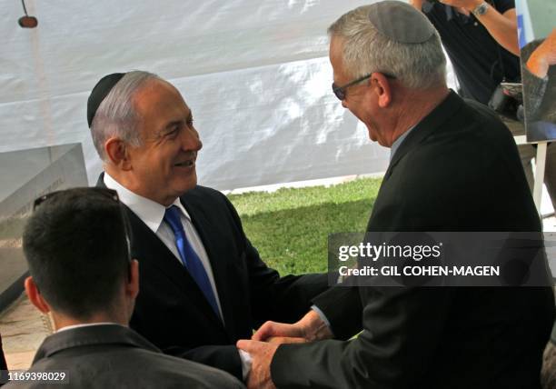 Israeli Prime Minister Benjamin Netanyahu greets Benny Gantz, leader of Blue and White party, at a memorial ceremony for late Israeli president...