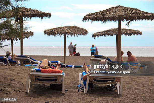 Elderly tourists relax on a beach at La Tejita on March 25, 2011 in Tenerife, Spain. Tenerife is the biggest of the Canary Islands and year-round...