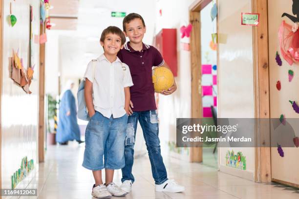 young boys in school hall - two young arabic children only indoor portrait stock-fotos und bilder