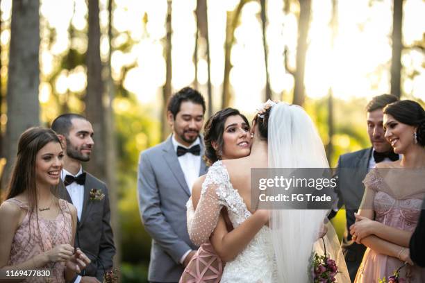 emotional bride being congratulated by the wedding guests - sisterhood stock pictures, royalty-free photos & images