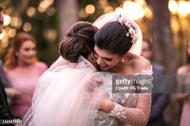 emotionele bruid wordt gefeliciteerd door haar moeder - bruidsmeisje stockfoto's en -beelden