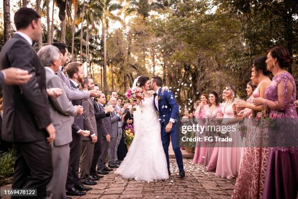 confettis jetant sur le couple heureux de jeunes mariés - cérémonie du mariage photos et images de collection