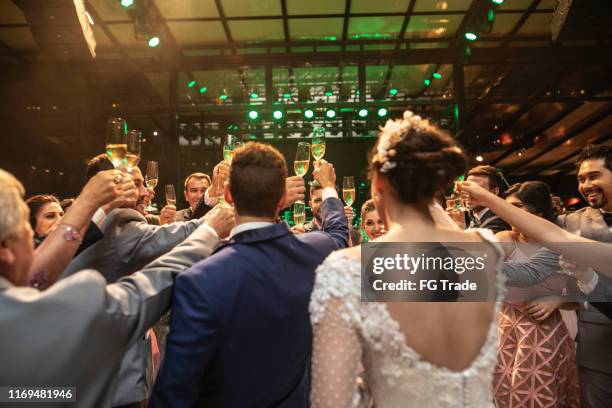 braut, bräutigam und hochzeitsgäste machen einen toast - wedding party stock-fotos und bilder