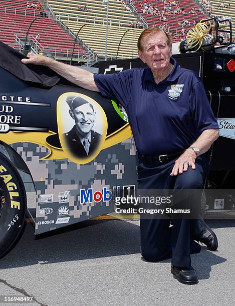 Hall of Famer Bud Moore poses by a photograph of himself on the car of Ryan Newman, driver of the U.S. Army 236th Birthday/Bud Moore NASCAR Hall of...