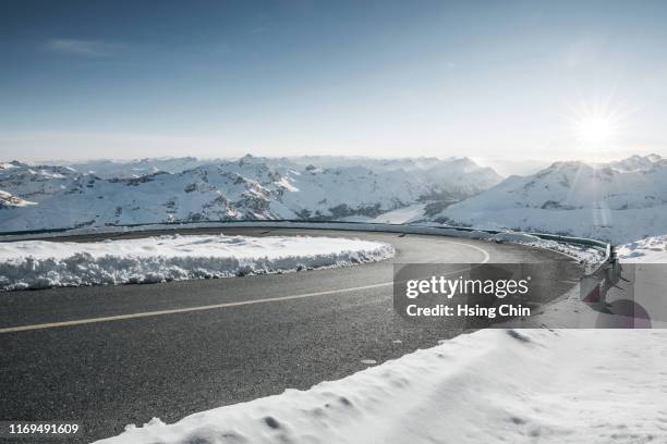 snow mountain road - bergstrasse stock-fotos und bilder