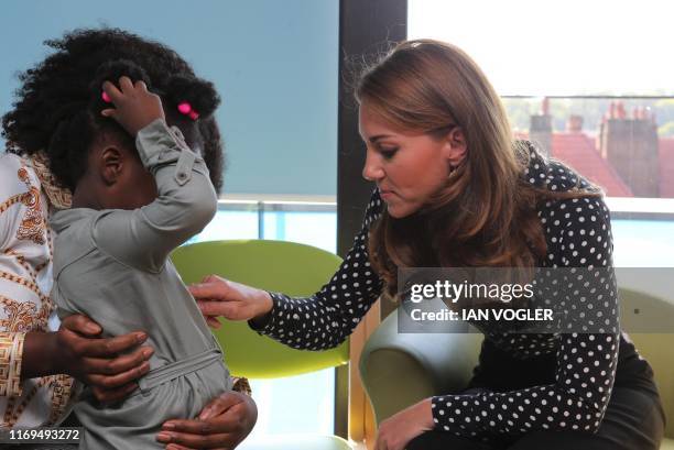 Britain's Catherine, Duchess of Cambridge gestures during her visit to the Sunshine House Children and Young People's Health and Development Centre...