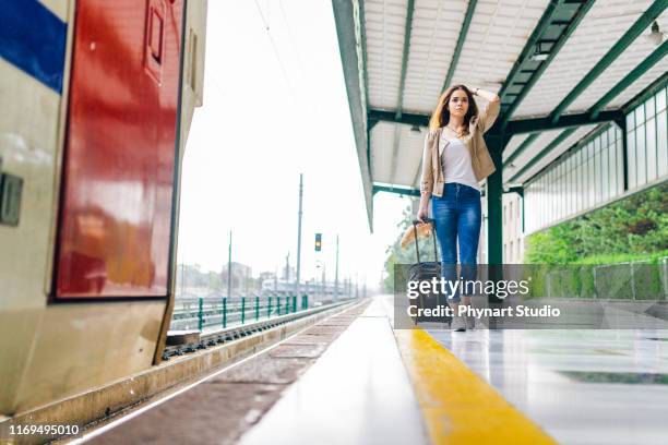 vrouw die de trein mist en van achteren uitkijkt - missed train stockfoto's en -beelden