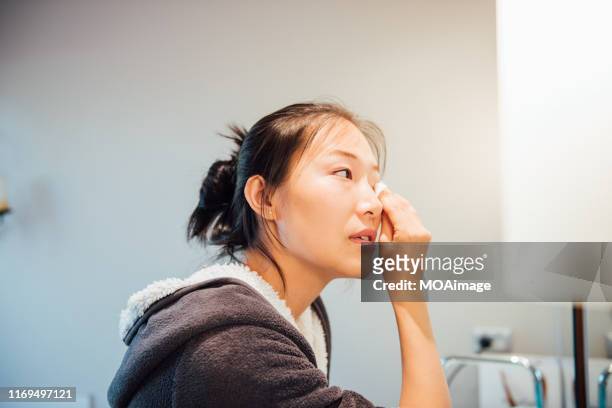 a young asian woman is washing her face - removing make up stock pictures, royalty-free photos & images