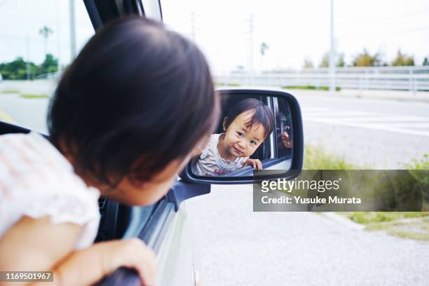 portrait of little girl in side-view mirror of car - railroad car ストックフォトと画像