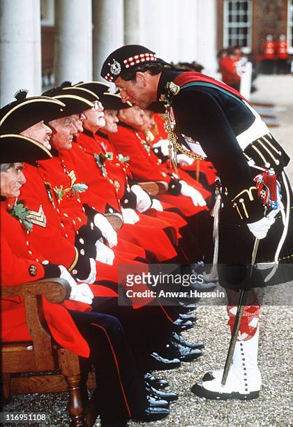 The Prince of Wales, wearing a kilt, chats to Chelsea Pensioners when he visits Chelsea Hospital in 1992.