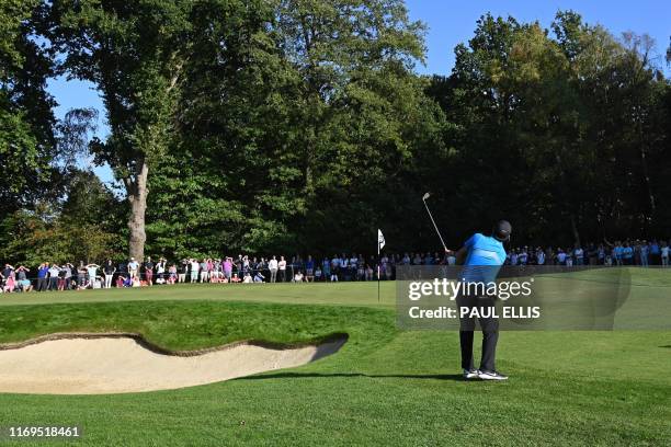 Golfer Patrick Reed chips onto the 15th green on day one of the golf PGA Championship at Wentworth Golf Club in Surrey, south west of London, on...