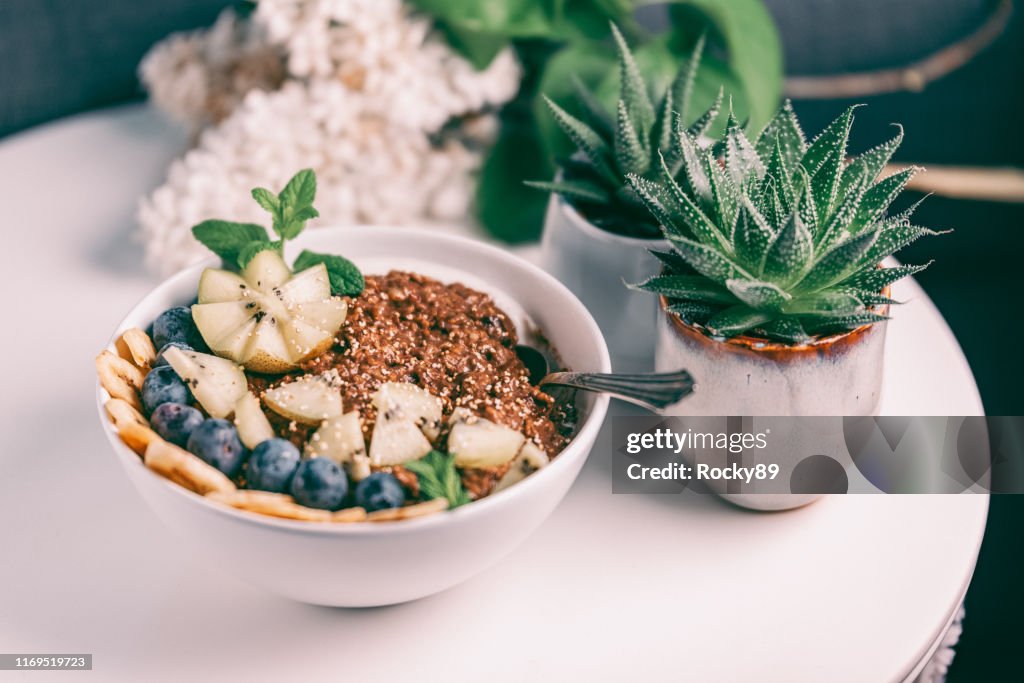 Bio Schokolade und Buchweizen Porridge Schale gekrönt mit Banane, Heidelbeeren, Kiwi und geknallt Amaranth
