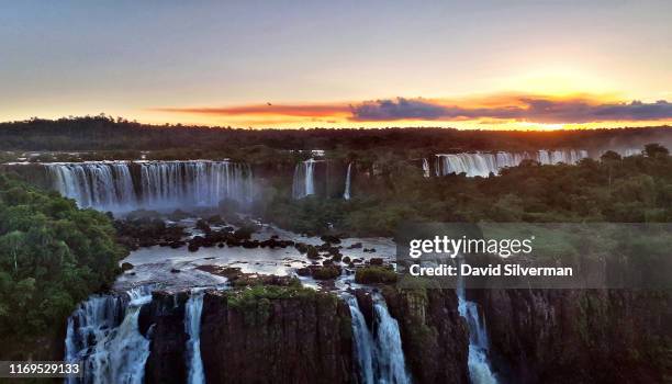 Sunset panoramic view of the Argentinian side of the waterfalls on April 8, 2019 in the Iguaçu National Park, Brazil. The falls, which straddle the...