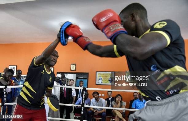 Former French WBA super-lightweight champion Souleymane M'Baye takes part in a training boxing match in front of French Sports Minister Roxana...