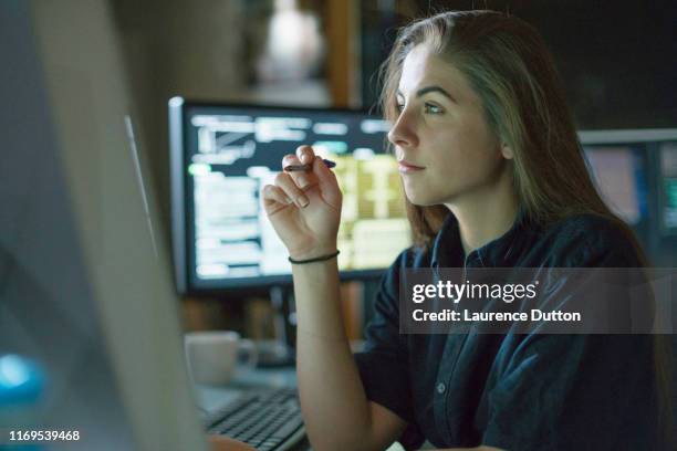 mujer monitorea oficina oscura - periodista fotografías e imágenes de stock