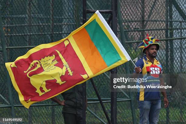 Sri Lankan cricket fan waves national flag as cheering during day one of the Second Test match between Sri Lanka and New Zealand at P Sara Oval...