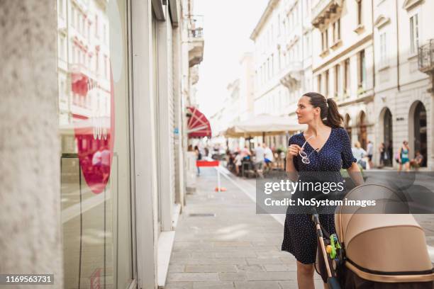 femme avec l'achat de fenêtre de poussette de chéri - femme poussette rue photos et images de collection