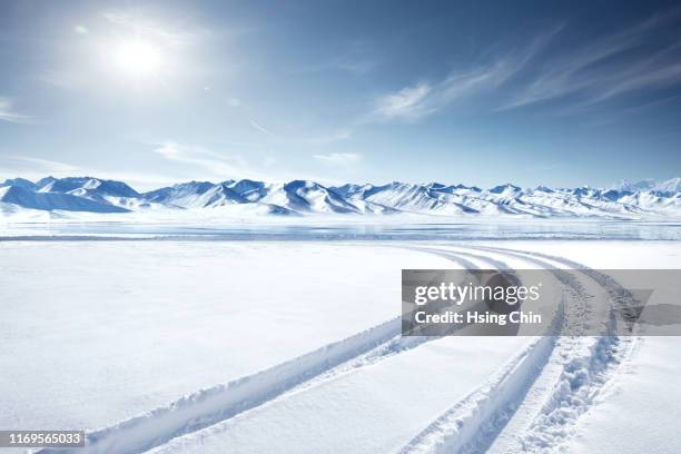 snow mountain and lake in winter - snow covered road stock-fotos und bilder