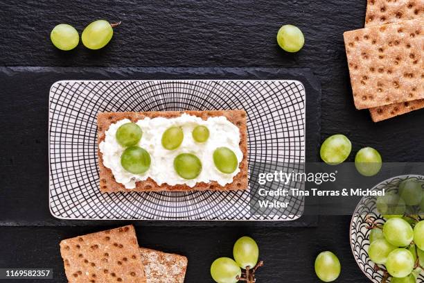 crispbread buiscuit with cream cheese and grapes on a dish. - schist fotografías e imágenes de stock