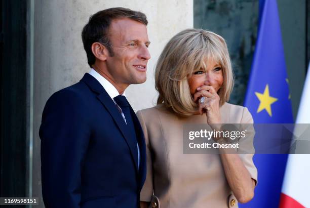 French President Emmanuel Macron and his wife Brigitte Macron wait for Greek Prime Minister Kyriakos Mitsotakis prior to their meeting at the Elysee...