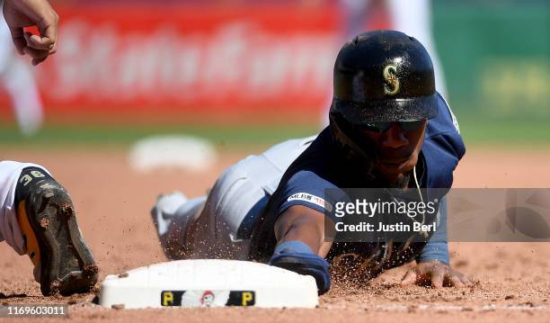 Shed Long of the Seattle Mariners dives back to first base on a pickoff attempt by Joe Musgrove of the Pittsburgh Pirates in the fifth inning during...