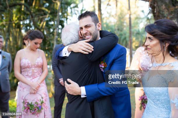 emotional groom being congratulated by the wedding guests - man crying tears stock pictures, royalty-free photos & images