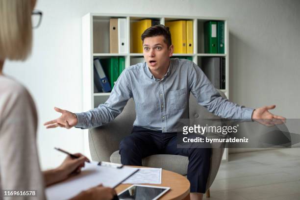 depressed man speaking to a therapist - things that go together imagens e fotografias de stock