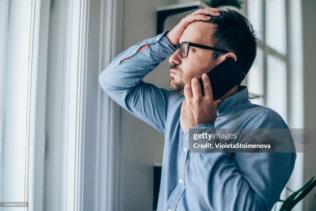 Frustrated businessman using phone