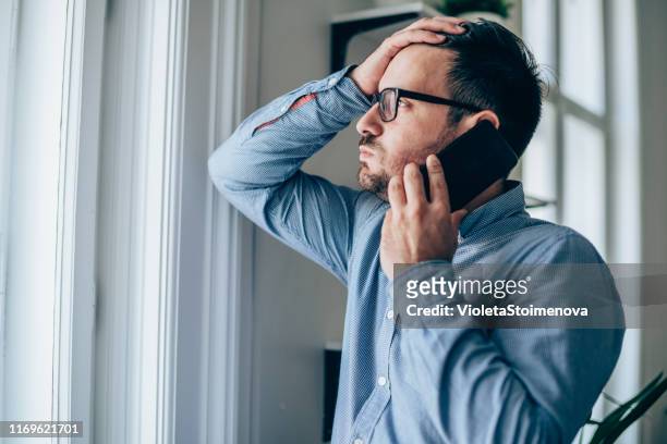 frustrated businessman using phone - emotional stress stock pictures, royalty-free photos & images