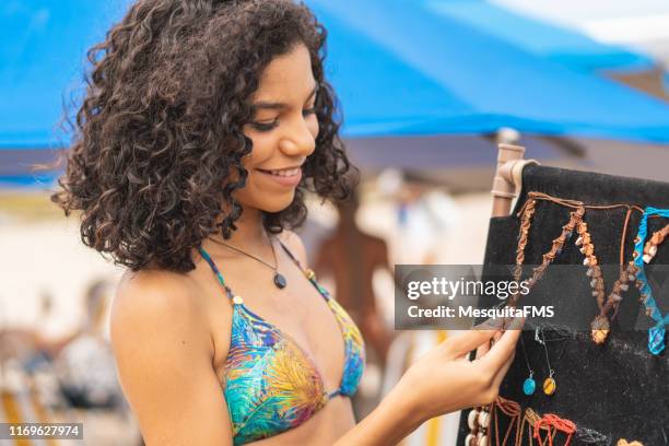 tourist buying costume jewelry at the beach - swimwear store stock pictures, royalty-free photos & images