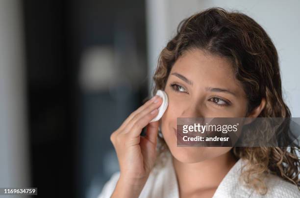 beautiful woman cleaning her face with a cotton pad - cotton pad stock pictures, royalty-free photos & images