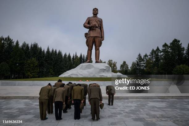 Photo taken on September 13, 2019 shows people paying their respects before a statue of late North Korean leader Kim Il Sung in North Korea's...