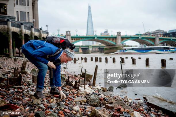 Lara Maiklem, a mudlark searches for treasure at low tide along the river Thames in central London on May 29, 2019. - Treading her way along the...