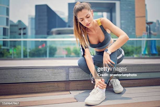 injured runner woman is sitting on the city stairs - injured runner stock pictures, royalty-free photos & images