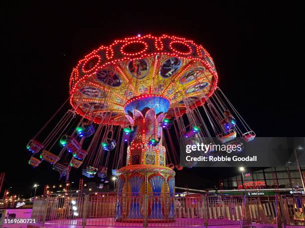 people on an illuminated carousel - carrossel imagens e fotografias de stock
