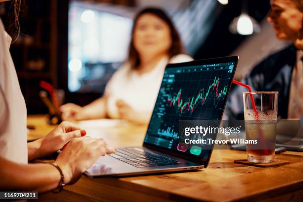 mixed group of millennial aged friends discuss investing and cryptocurrency trading - investment foto e immagini stock