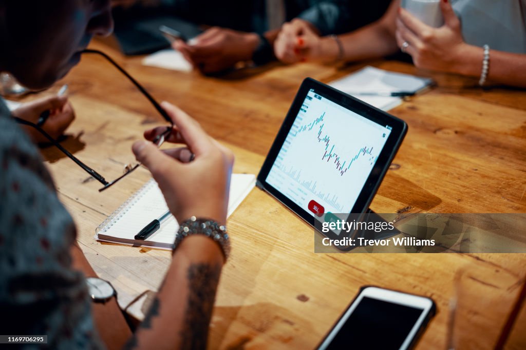 Mixed group of millennial aged friends discuss investing and cryptocurrency trading