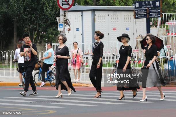 Fashion grandmas' models Wang Xinghuo, Lin Wei, Wang Nianwen and Sun Yang cross a street during a photo shooting on July 16, 2019 in Beijing, China....