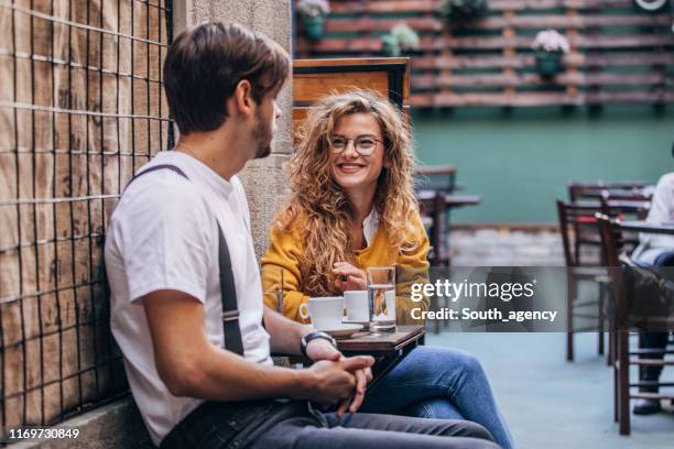 young couple sitting in cafe - coffee shop couple stock pictures, royalty-free photos & images