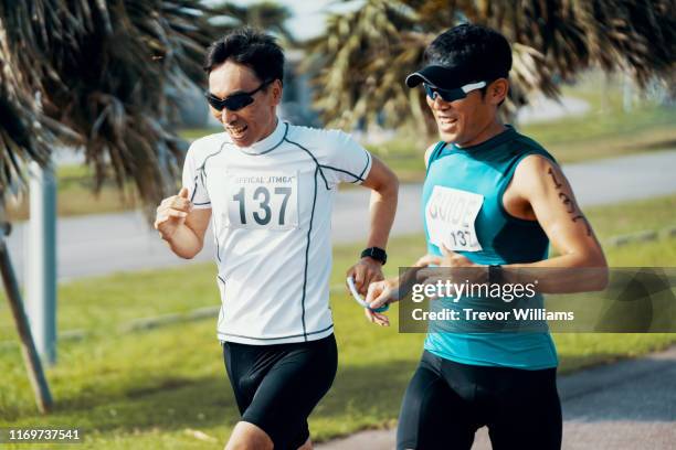 blind triathlete running and training with his guide - führender rennsport stock-fotos und bilder