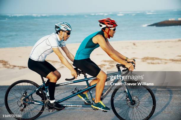 blind triathlete and his guide training on their tandem bicycle - ciclismo tandem fotografías e imágenes de stock