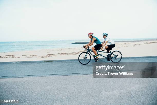 blind triathlete and his guide training on their tandem bicycle - triathlete stock pictures, royalty-free photos & images