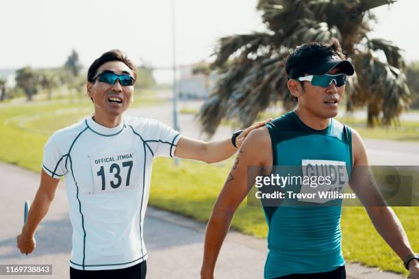 Blind triathlete and his guide walking before or after a triathlon event