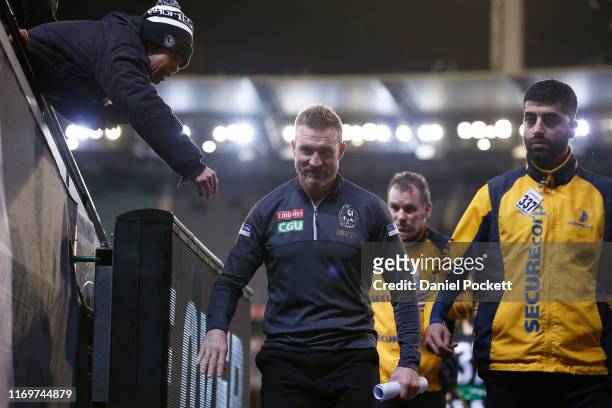Magpies fan greets Magpies head coach Nathan Buckley after the round 23 AFL match between the Collingwood Magpies and the Essendon Bombers at...