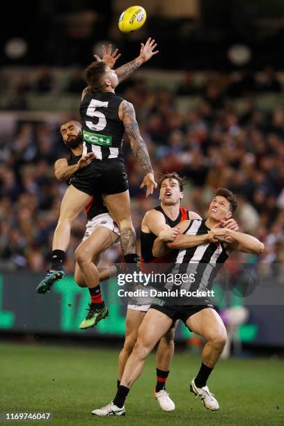 Jamie Elliott of the Magpies attempts to mark the ball against Adam Saad of the Bombers during the round 23 AFL match between the Collingwood Magpies...