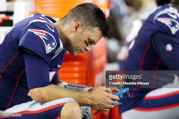 Tom Brady of the New England Patriots reviews information on a Microsoft Surface tablet during the preseason game between the Carolina Panthers and...