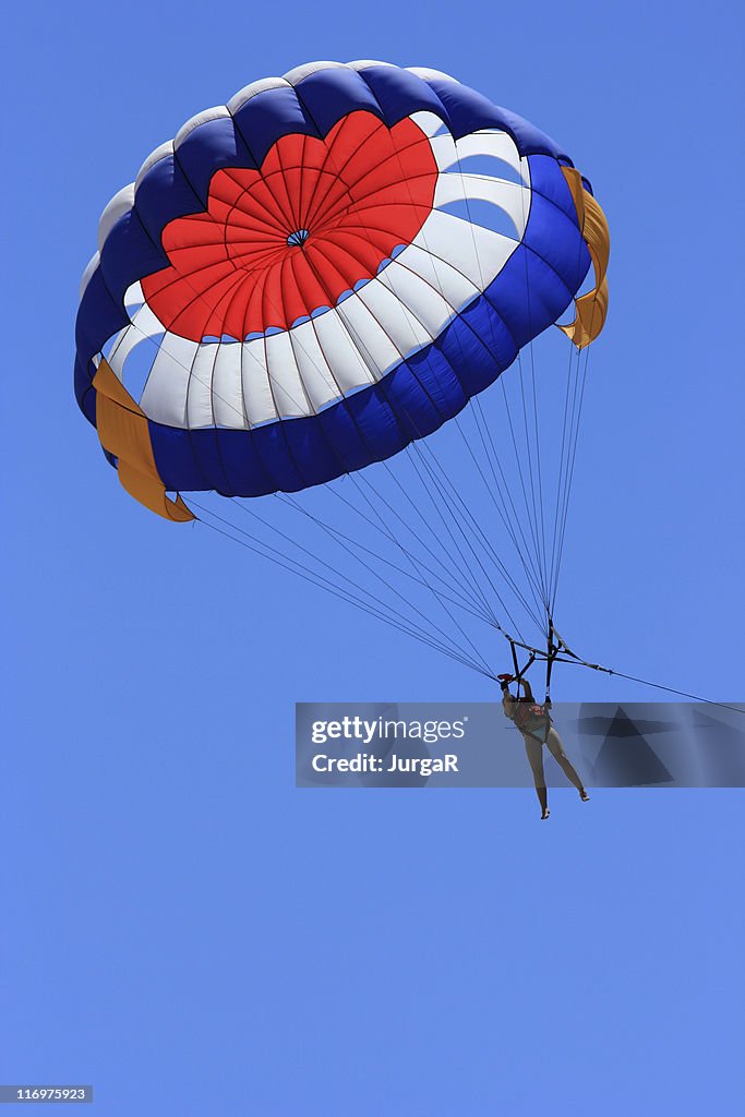 A person parasailing in a big blue sky