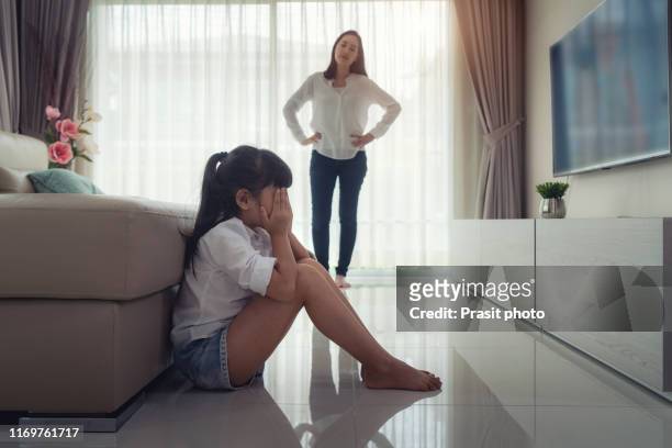 asian mothers scold you for making a mistake. the children bent down, kneed and admitted their mistakes on the floor of the house. - mother upset stock-fotos und bilder