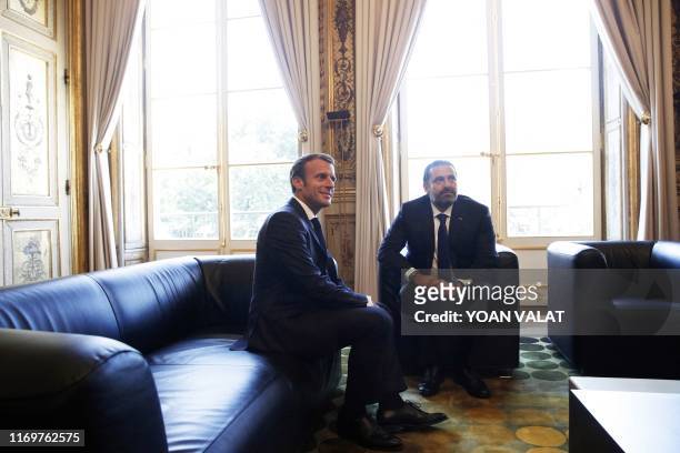 French President Emmanuel Macron speaks with Lebanese Prime Minister Saad Hariri prior to their meeting at the Elysee Palace in Paris, France, 20...